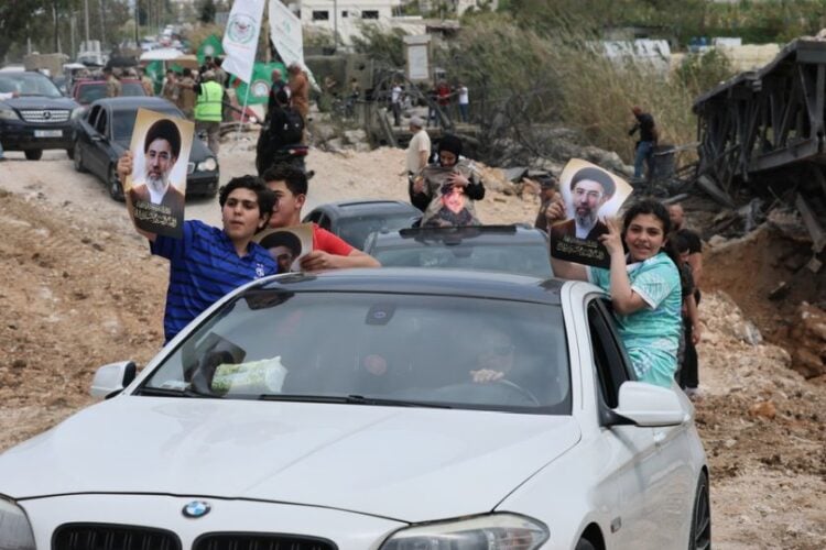 Εκτοπισμένοι πανηγυρίζουν μέσα στα οχήματά τους καθώς περιμένουν στην ουρά στη γέφυρα Κασμίγια, επιστρέφοντας στα σπίτια τους κατά μήκος της ακτής κοντά στην Τύρο, σήμερα, στο νότιο Λίβανο (φωτ.: EPA/WAEL HAMZEH)