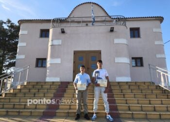 Τα δύο ποντιόπουλα Παύλος Φωτιάδης και Παναγιώτης Κιουρτσίδης που κέρδισαν στον ποιητικό διαγωνισμό γράφοντας στην ποντιακή διάλεκτο, μπροστά από τον Σύλλογο Ποντίων Ποντοηράκλειας «Διγενής Ακρίτας»  (φωτ.: Αλεξία Ιωαννίδου)