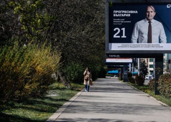 Γυναίκα περνά μπροστά από προεκλογική αφίσα του κόμματος «Προοδευτική Βουλγαρία» στη Σόφια (φωτ.: EPA / Borislav Troshev)