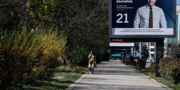 Γυναίκα περνά μπροστά από προεκλογική αφίσα του κόμματος «Προοδευτική Βουλγαρία» στη Σόφια (φωτ.: EPA / Borislav Troshev)