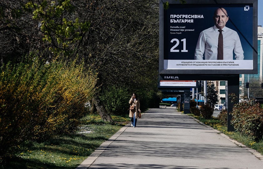 Γυναίκα περνά μπροστά από προεκλογική αφίσα του κόμματος «Προοδευτική Βουλγαρία» στη Σόφια (φωτ.: EPA / Borislav Troshev)