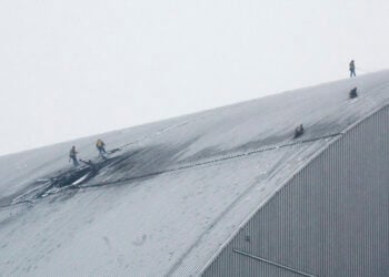 Εργάτες στο κατεστραμμένο προστατευτικό περίβλημα του αντιδραστήρα 4 στο Τσερνόμπιλ, μετά από πλήγμα ρωσικού drone. 14 Φεβρουαρίου 2025 (φωτ.: EPA / Sergey Dolzhenko)
