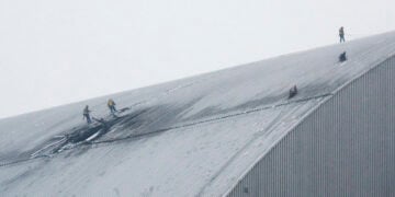 Εργάτες στο κατεστραμμένο προστατευτικό περίβλημα του αντιδραστήρα 4 στο Τσερνόμπιλ, μετά από πλήγμα ρωσικού drone. 14 Φεβρουαρίου 2025 (φωτ.: EPA / Sergey Dolzhenko)