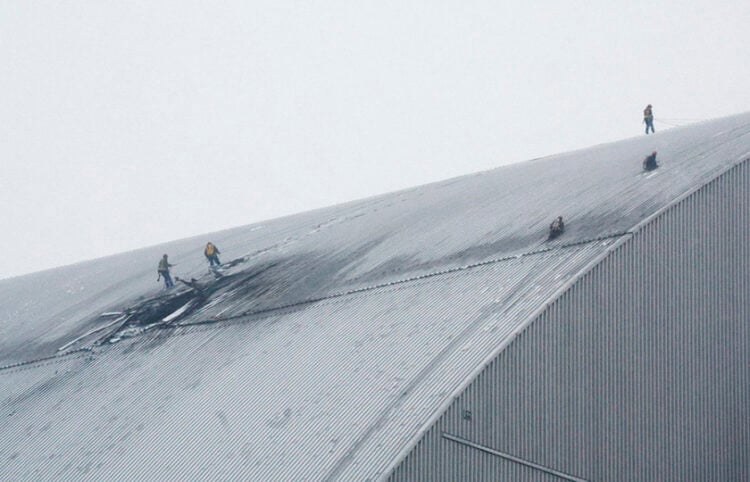 Εργάτες στο κατεστραμμένο προστατευτικό περίβλημα του αντιδραστήρα 4 στο Τσερνόμπιλ, μετά από πλήγμα ρωσικού drone. 14 Φεβρουαρίου 2025 (φωτ.: EPA / Sergey Dolzhenko)