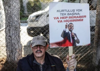 Υποστηρικτής του Ιμάμογλου με πλακάτ που γράφει «Καμία σωτηρία αν είσαι μόνος. Ή όλοι μαζί, ή κανείς» (φωτ.: EPA / Erdem Sahin)