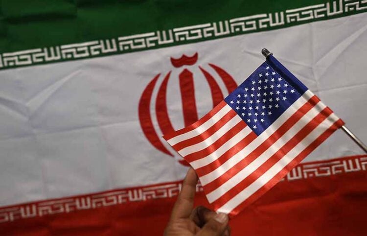 Καταστηματάρχης δείχνει σημαίες του Ιράν και των ΗΠΑ σε κατάστημα στο Καράτσι του Πακιστάν (φωτ.: EPA / Shahzaib Akber)