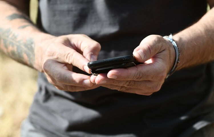 Άνδρας κοιτάζει το κινητό του (φωτ.: EUROKINISSI / Τατιάνα Μπόλαρη)