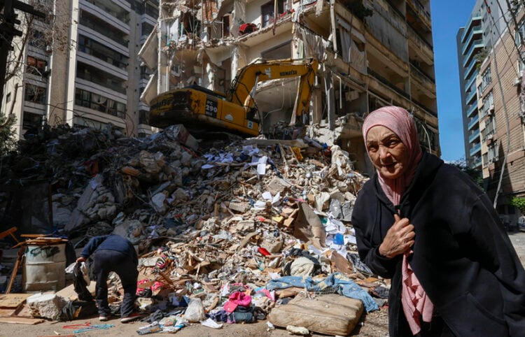 Γυναίκα περπατά δίπλα σε κατεστραμμένο κτήριο κατοικιών την επομένη ισραηλινού αεροπορικού πλήγματος στη συνοικία Άιν ελ Μρέισα της Βηρυτού, στον Λίβανο. 9 Απριλίου 2026 (φωτ.: EPA / Wael Hamzeh)