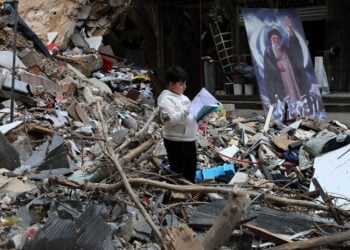 Ένα αγόρι διαβάζει μέσα στα ερείπια βομβαρδισμένου σπιτιού στα προάστια της Βηρυτού, στον Λίβανο. 20 Απριλίου 2026 (φωτ.: EPA / Wael Hamzeh)