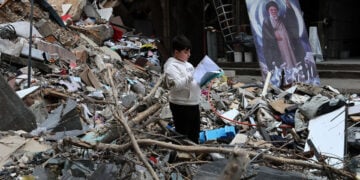 Ένα αγόρι διαβάζει μέσα στα ερείπια βομβαρδισμένου σπιτιού στα προάστια της Βηρυτού, στον Λίβανο. 20 Απριλίου 2026 (φωτ.: EPA / Wael Hamzeh)