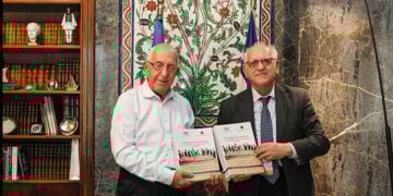 Νικήτας Κακλαμάνης και Νίκος Ουζούνογλου με τον τόμο που περιλαμβάνει τα πρακτικά των διαπραγματεύσεων και το σχέδιο όρων της Συνθήκης της Λοζάνης (φωτ.: Βουλή των Ελλήνων / Δημήτριος Κλεάνθους)