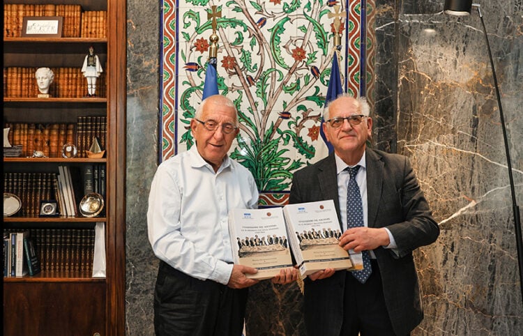 Νικήτας Κακλαμάνης και Νίκος Ουζούνογλου με τον τόμο που περιλαμβάνει τα πρακτικά των διαπραγματεύσεων και το σχέδιο όρων της Συνθήκης της Λοζάνης (φωτ.: Βουλή των Ελλήνων / Δημήτριος Κλεάνθους)