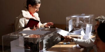 Γυναίκα παραλαμβάνει το ψηφοδέλτιό της σε εκλογικό τμήμα στο Κιουστεντίλ, κατά τη διάρκεια βουλευτικών εκλογών στη Βουλγαρία, 27 Οκτωβρίου 2024 (φωτ.: EPA / Georgi Licovski)