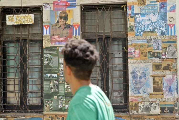 Άνθρωπος περνά μπροστά από ένα σπίτι καλυμμένο με αφίσες στην Αβάνα της Κούβας (φωτ.: EPA/ ERNESTO MASTRASCUSA)