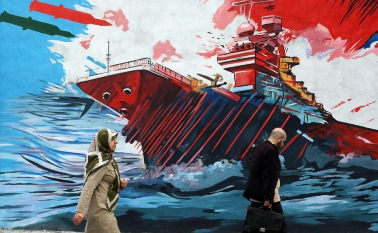 Ιρανοί περνούν μπροστά από μια τοιχογραφία με αντι-αμερικανικά και αντι-ισραηλινά μηνύματα σε δρόμο της Τεχεράνης (φωτ.: EPA/ABEDIN TAHERKENAREH)