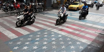 Ιρανοί οδηγοί περνούν πάνω από ζωγραφισμένες σημαίες των ΗΠΑ και του Ισραήλ σε δρόμο της Τεχεράνης (φωτ.: EPA / Abedin Taherkenareh)