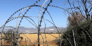 Άποψη της «νεκρής ζώνης» που χωρίζει την Κύπρο, με τα συρματοπλέγματα και τη σημαία του ψευδοκράτους να δεσπόζει στο βουνό πάνω από τη Λευκωσία. Η Κύπρος παραμένει διαιρεμένη από το 1974, όταν η Τουρκία εισέβαλε και κατέλαβε το βόρειο τμήμα του νησιού
(φωτ.: EPA / Katia Christodoulou)