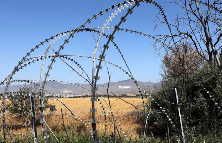 Άποψη της «νεκρής ζώνης» που χωρίζει την Κύπρο, με τα συρματοπλέγματα και τη σημαία του ψευδοκράτους να δεσπόζει στο βουνό πάνω από τη Λευκωσία. Η Κύπρος παραμένει διαιρεμένη από το 1974, όταν η Τουρκία εισέβαλε και κατέλαβε το βόρειο τμήμα του νησιού
(φωτ.: EPA / Katia Christodoulou)