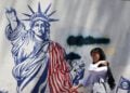 Μια Ιρανή περνάει μπροστά από μια αντιαμερικανική τοιχογραφία δίπλα στην πρώην πρεσβεία των ΗΠΑ στην Τεχεράνη (φωτ.: EPA/ ABEDIN TAHERKENAREH)