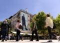 Άνθρωποι περπατούν στην κεντρική πλατεία μπροστά από μια φωτογραφία του πρώτου Προέδρου του Κοσόβου, Ιμπραήμ Ρουγκόβα, που είναι αναρτημένη σε κτήριο στην Πρίστινα, Κόσοβο (φωτ.: EPA/GEORGI LICOVSKI)