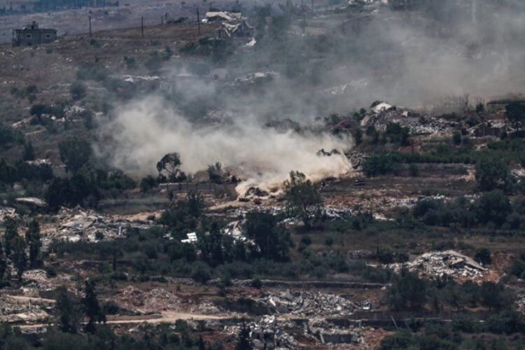 Ισραηλινό άρμα μάχης πραγματοποιεί ελιγμούς καθώς αυτοκινητοπομπή της Προσωρινής Δύναμης των Ηνωμένων Εθνών στον Λίβανο (UNIFIL) κινείται ανάμεσα σε κατεστραμμένα σπίτια στο χωριό Μέις Ελ Τζαμπάλ του νοτίου Λιβάνου, όπως φαίνεται από την ισραηλινή πλευρά των συνόρων στην Άνω Γαλιλαία (φωτ.: EPA/ATEF SAFADI)