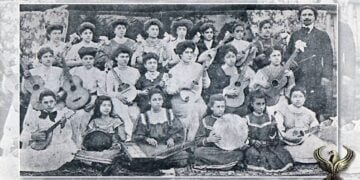 Η Μαντολινάτα Σαμψούντας, αποτελούμενη από 25 νέες μουσικούς μαζί με τον μαέστρο και ιδρυτή της Αχιλλέα Καρακάση (πηγή: Ψηφιακή-ερευνητική βάση δεδομένων «Κυψέλη» του Πανεπιστημίου Κρήτης)