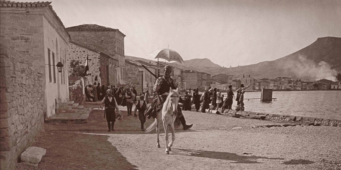 Σε πρώτο πλάνο ένας έφιππος τσέτης, Τούρκος άτακτος στρατιώτης, μέλος αντάρτικων
μονάδων, και τρεις άλλοι με λάφυρα στα χέρια τον ακολουθούν. Πίσω τους, Έλληνες κάτοικοι έχουν συγκεντρωθεί μπροστά στο σπίτι του Σαρτιό, με τη γαλλική σημαία
υψωμένη για να τους προστατεύει, κάνοντας απεγνωσμένα νόημα στα πλοιάρια για να
προσεγγίσουν. 13 Ιουνίου 1914 (πηγή: Χάρης Γιακουμής / Kallimages, Paris)