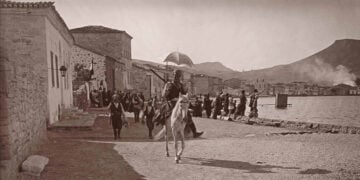 Σε πρώτο πλάνο ένας έφιππος τσέτης, Τούρκος άτακτος στρατιώτης, μέλος αντάρτικων
μονάδων, και τρεις άλλοι με λάφυρα στα χέρια τον ακολουθούν. Πίσω τους, Έλληνες κάτοικοι έχουν συγκεντρωθεί μπροστά στο σπίτι του Σαρτιό, με τη γαλλική σημαία
υψωμένη για να τους προστατεύει, κάνοντας απεγνωσμένα νόημα στα πλοιάρια για να
προσεγγίσουν. 13 Ιουνίου 1914 (πηγή: Χάρης Γιακουμής / Kallimages, Paris)
