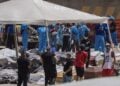 Άνθρωποι παραλαμβάνουν τις σορούς συγγενών τους που έχασαν τη ζωή τους από τους σεισμούς, σε λιμάνι της Λα Γουάιρα στη Βενεζουέλα (φωτ.: EPA/Henry Chirinos ΠΡΟΣΟΧΗ: ΣΚΛΗΡΗ ΕΙΚΟΝΑ)