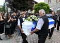 Σκεπασμένο με την ελληνική σημαία το λευκό φέρετρο
της 45χρονης αστυνομικού που δολοφονήθηκε από τον σύζυγό της στη Δράμα. Τετάρτη 17 Ιουνίου 2026 (φωτ.: EUROKINISSI / Σεραφείμ Καραμβαλάσης)