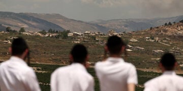 Υπερορθόδοξοι Εβραίοι από το Μπρούκλιν της Νέας Υόρκης παρακολουθούν την πλευρά του Λιβάνου από τη Μετούλα, στα σύνορα Ισραήλ-Λιβάνου, στη βόρεια Γαλιλαία (φωτ.: EPA / Atef Safadi)