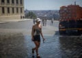 Γυναίκα δροσίζεται με νερό μπροστά στο Κάστρο της Πράγας, καθώς η Τσεχία δοκιμάζεται από το ακραίο κύμα καύσωνα που πλήττει την Ευρώπη (φωτ.: EPA / Martin Divisek)