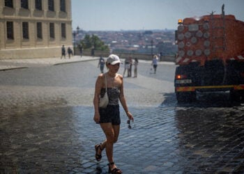 Γυναίκα δροσίζεται με νερό μπροστά στο Κάστρο της Πράγας, καθώς η Τσεχία δοκιμάζεται από το ακραίο κύμα καύσωνα που πλήττει την Ευρώπη (φωτ.: EPA / Martin Divisek)