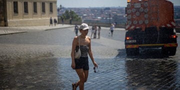 Γυναίκα δροσίζεται με νερό μπροστά στο Κάστρο της Πράγας, καθώς η Τσεχία δοκιμάζεται από το ακραίο κύμα καύσωνα που πλήττει την Ευρώπη (φωτ.: EPA / Martin Divisek)