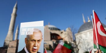 Διαδηλωτές κρατούν φωτογραφία του Νετανιάχου με το σύνθημα «Θα έχει την κατάληξη του Χίτλερ», κατά τη διάρκεια συγκέντρωσης στην πλατεία της Αγίας Σοφίας στην Κωνσταντινούπολη. 3 Αυγούστου 2024 (φωτ.: EPA / Erdem Sahin)