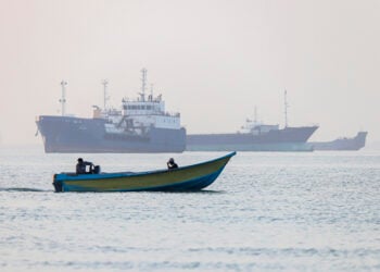 Ιρανοί ψαράδες πλέουν ανάμεσα σε πλοία που έχουν ακινητοποιηθεί στα Στενά του Ορμούζ, ανοιχτά του Μπαντάρ Αμπάς στο νότιο Ιράν, την 1η Ιουνίου 2026 (φωτ.: EPA / Amirhossein Khorgooei / ISNA News Agency)
