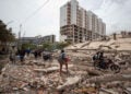 Άνθρωποι περπατούν ανάμεσα στα ερείπια κτηρίων που υπέστησαν ζημιές από τους σεισμούς στη Λα Γκουάιρα της Βενεζουέλας, Παρασκευή 25 Ιουνίου 2026 (φωτ.: EPA / Ronald Pena R)