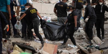 Μέλη του Σώματος Επιστημονικών, Εγκληματολογικών και Ποινικών Ερευνών της Βενεζουέλας μεταφέρουν σορούς, στη Λα Γκουάιρα (φωτ.: EPA / Ronald Pena R)