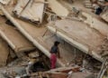 Μια γυναίκα κοιτάζει μέσα στα χαλάσματα κτηρίου που κατέρρευσε μετά τον φονικό σεισμό στη Λα Γουάιρα της Βενεζουέλας. 27 Ιουνίου 2026 (φωτ.: EPA / Henry Chirinos)