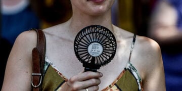 Μια γυναίκα δροσίζεται με φορητό ανεμιστήρα χειρός στο Βερολίνο, στις 27 Ιουνίου 2026 (φωτ.: EPA / Filip Singer)