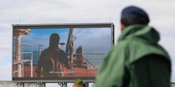 Μαχητής των Χούθι κοιτάζει ψηφιακή πινακίδα που απεικονίζει επίθεση σε πλοίο στην Ερυθρά Θάλασσα, κατά τη διάρκεια συγκέντρωσης αλληλεγγύης προς το Ιράν στη Σαναά της Υεμένης. 27 Μαρτίου 2026 (φωτ.: EPA /  Yahya Arhab)