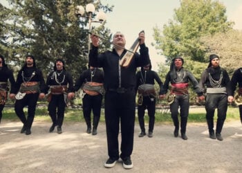 Ο Δημήτρης Καρασαββίδης με χορευτές της Ευξείνου Λέσχης Αθηνών, σε στιγμιότυπο από το βιντεοκλίπ (πηγή: YouTube / 
Dimitris Karasavvidis)