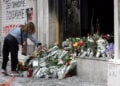 Γυναίκα αφήνει λουλούδια στο καμένο υποκατάστημα της Marfin στη Σταδίου, στη μνήμη των τριών εργαζομένων. Πέμπτη 6 Μαΐου 2010 (φωτ.: ΑΠΕ-ΜΠΕ / Παντελής Σαΐτας)