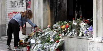 Γυναίκα αφήνει λουλούδια στο καμένο υποκατάστημα της Marfin στη Σταδίου, στη μνήμη των τριών εργαζομένων. Πέμπτη 6 Μαΐου 2010 (φωτ.: ΑΠΕ-ΜΠΕ / Παντελής Σαΐτας)