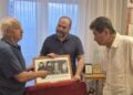 Ο Γιώργος Λυσαρίδης παραδίδει στον πρόεδρο της Ευξείνου Λέσχης Θεσσαλονίκης  Θεοδόση Κυριακίδη τη φωτογραφική σύνθεση υπό το βλέμμα του επιτίμου προέδρου της Λέσχης Κώστα Γαβρίδη (φωτ.: facebook.com/peristereota)