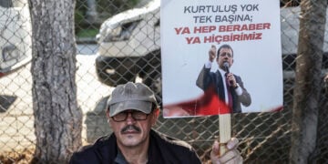 Υποστηρικτής του φυλακισμένου δημάρχου Κωνσταντινούπολης Εκρέμ Ιμάμογλου κρατά πλακάτ με το σύνθημα «Δεν υπάρχει σωτηρία για κανέναν μόνο του – ή όλοι μαζί ή κανείς», έξω από τις φυλακές Μαρμαρά στην Κωνσταντινούπολη. 15 Ιανουαρίου 2026 (φωτ.: EPA / Erdem Sahin)
