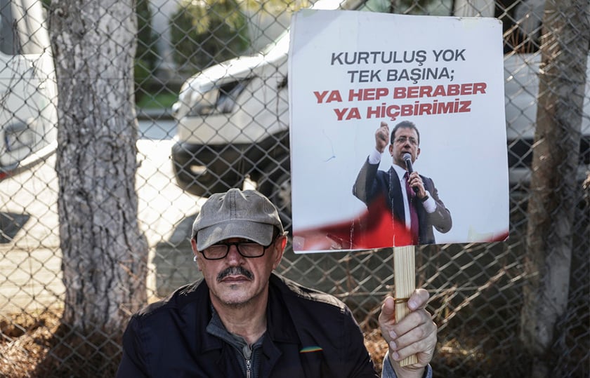 Υποστηρικτής του φυλακισμένου δημάρχου Κωνσταντινούπολης Εκρέμ Ιμάμογλου κρατά πλακάτ με το σύνθημα «Δεν υπάρχει σωτηρία για κανέναν μόνο του – ή όλοι μαζί ή κανείς», έξω από τις φυλακές Μαρμαρά στην Κωνσταντινούπολη. 15 Ιανουαρίου 2026 (φωτ.: EPA / Erdem Sahin)