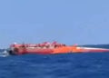 Το αναποδογυρισμένο καταμαράν ανοιχτά της κατεχόμενης Κερύνειας, με επιβαίνοντες να περιμένουν τη διάσωσή τους πάνω στο εκτεθειμένο τμήμα του σκάφους (φωτ.: Takvim / στιγμιότυπο από βίντεο)