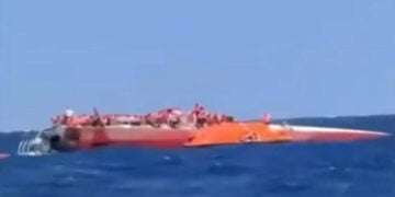 Το αναποδογυρισμένο καταμαράν ανοιχτά της κατεχόμενης Κερύνειας, με επιβαίνοντες να περιμένουν τη διάσωσή τους πάνω στο εκτεθειμένο τμήμα του σκάφους (φωτ.: Takvim / στιγμιότυπο από βίντεο)