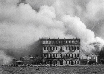 Η Σμύρνη στις φλόγες, σε καρέ από το επεισόδιο «Έξοδος» της σειράς ιστορικών ντοκιμαντέρ «Το Ρίζωμα». Η εικόνα έχει υποστεί τεχνική επεξεργασία ως προς τα χρώματα και την ποιότητα (πηγή: Αρχείο ΕΡΤ)